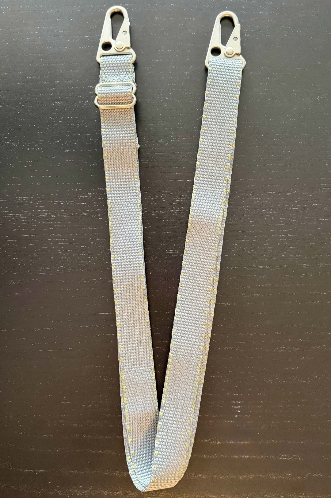 Gray webbing strap with buckles on a black background