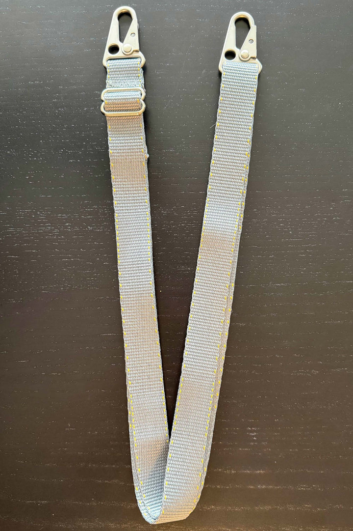 Gray webbing strap with buckles on a black background